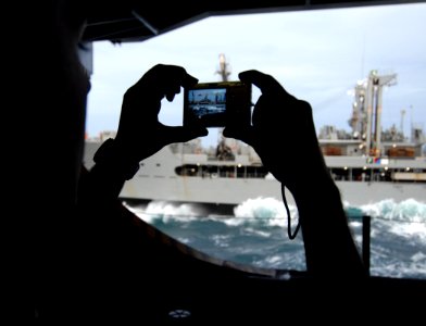 US Navy 070116-N-8923M-014 Machinist's Mate Fireman George Colon takes a photo from the hangar bay of the Nimitz-class aircraft carrier USS Harry S. Truman (CVN 75) as the Military Sealift Command supply ship USNS Patuxent (T-A