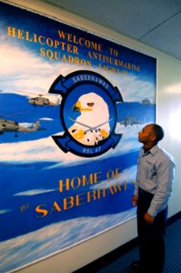 US Navy 070123-N-6410J-050 Airman Hadi R. El-Abiad assigned to Helicopter Antisubmarine Squadron Light Four Seven (HSL-47) looks at the mural he painted