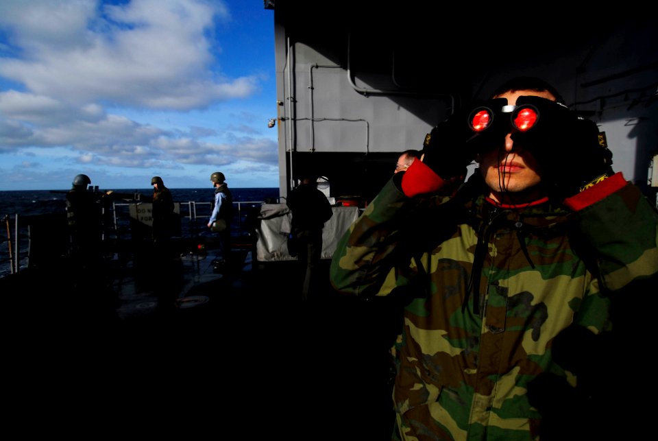 US Navy 070117-N-3729H-081 Gunner's Mate 3rd Class Josue Pichardo watches for a target to come into view while his shipmates prepare to fire a .50-caliber machine gun off the fantail during a live-fire exercise aboard USS John
