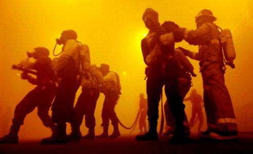 US Navy 070117-N-5345W-107 Fire fighting parties work side-by-side while battling a simulated out-of-control fire in the hangar bay during a general quarters drill aboard the Nimitz-class aircraft carrier USS Harry S. Truman (C