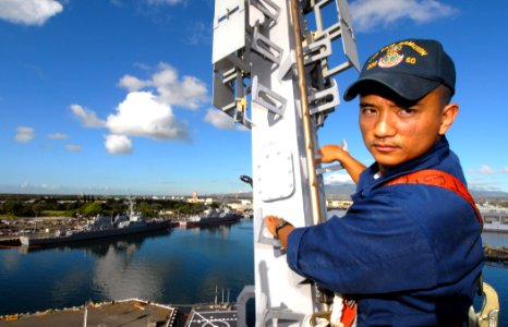 US Navy 070124-N-4965F-006 Electronics Technician 2nd Class Joseph Melchor, assigned to the Arleigh Burke-class guided-missile destroyer USS Paul Hamilton (DDG 60), climbs down the mast of the Paul Hamilton after completion of