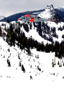 US Navy 070125-N-9150R-143 Helicopter in-flight rescue crewmen hang from an MH-60S Seahawk search and rescue (SAR) helicopter during a training mission in the North Cascade Mountains