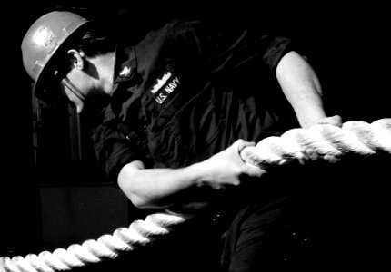 US Navy 070126-N-8923M-027 A Sailor assigned to deck department takes in a mooring line on the fantail as the Nimitz-class aircraft carrier USS Harry S. Truman (CVN 75) gets underway