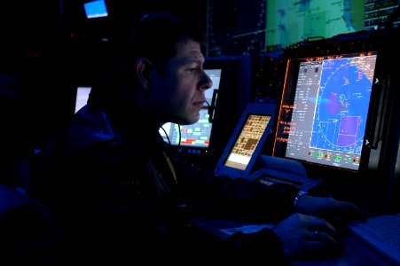 US Navy 070121-N-3038W-009 Tactical Action Officer (TAO), Lt. Josh Taylor, sits in the Combat Direction Center aboard the Nimitz-Class aircraft carrier USS John C. Stennis (CVN 74), during flight operations