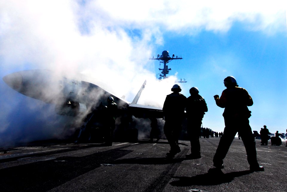 US Navy 070123-N-3729H-131 An F-A-18C Hornet assigned to the Blue Diamonds of Strike Fighter Squadron One Four Six (VFA-146) sits ready to launch as Sailors from air department clear the catapult
