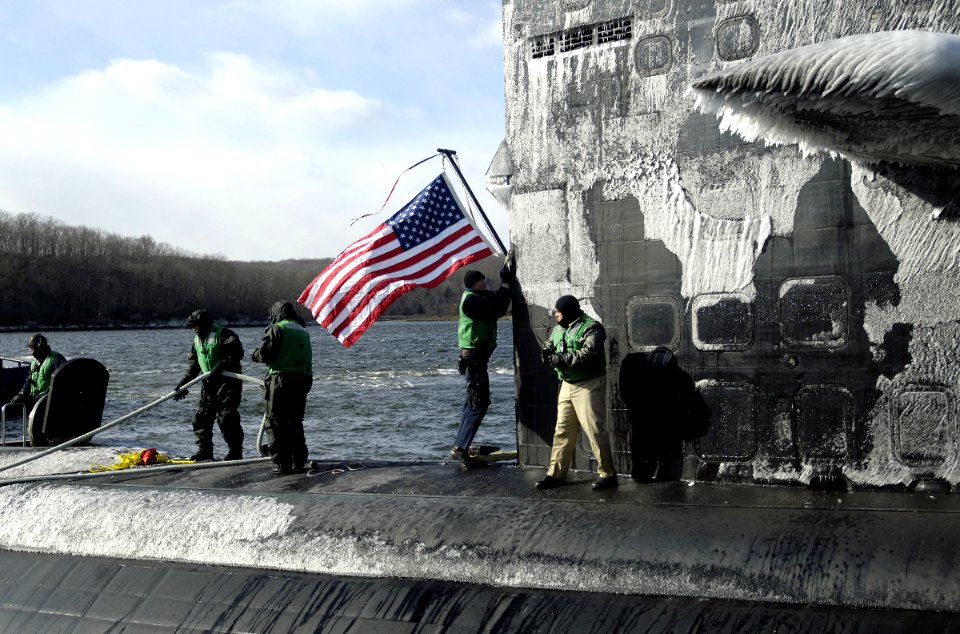 US Navy 070126-N-8467N-001 Sailors aboard Los Angeles-class fast attack submarine USS Philadelphia SSN 690 moor the boat to the pier and hoist the American flag upon return to Naval Submarine Base New London