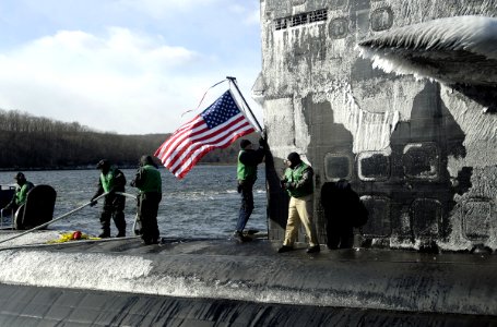 US Navy 070126-N-8467N-001 Sailors aboard Los Angeles-class fast attack submarine USS Philadelphia SSN 690 moor the boat to the pier and hoist the American flag upon return to Naval Submarine Base New London photo