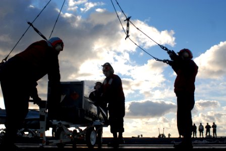 US Navy 070131-N-2959L-333 Sailors assigned to USS Ronald Reagan (CVN 76) combat systems department push a RIM-7 NATO Sea Sparrow missile into position under a grove crane
