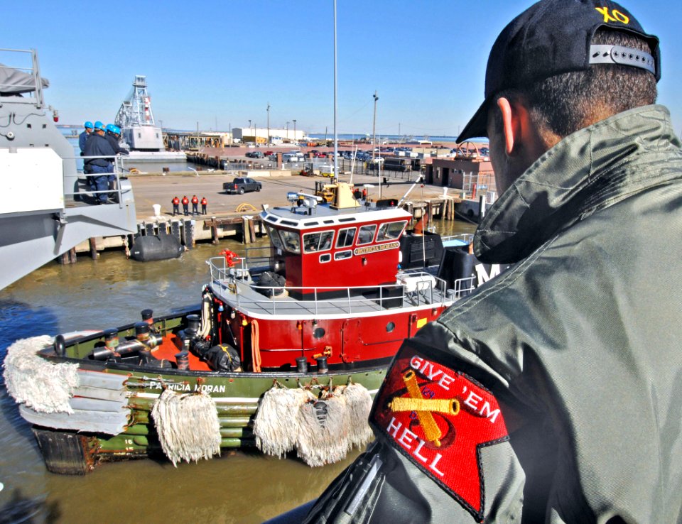 US Navy 070126-N-8923M-039 Executive Officer Cmdr. Ronald Reis watches from the fantail as a tugboat prepares to push the Nimitz-class aircraft carrier USS Harry S. Truman (CVN 75) out to sea