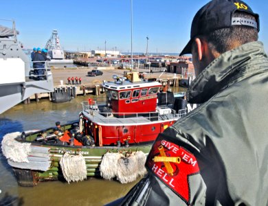 US Navy 070126-N-8923M-039 Executive Officer Cmdr. Ronald Reis watches from the fantail as a tugboat prepares to push the Nimitz-class aircraft carrier USS Harry S. Truman (CVN 75) out to sea