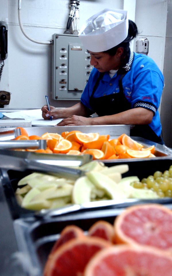 US Navy 070201-N-4776G-112 Culinary Specialist 2nd Class Jimnett Santos checks food order forms for accuracy in the galley aboard the Nimitz-class aircraft carrier USS Ronald Reagan (CVN 76)