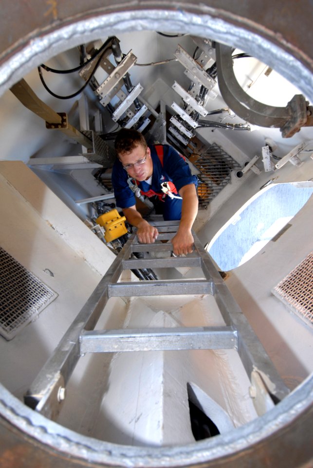 US Navy 070124-N-4965F-001 Electronics Technician 3rd Class Edward Mittelstaed, assigned to the Arleigh Burke-class guided-missile destroyer USS Paul Hamilton (DDG 60), climbs a ladder leading to the Tactical Air Navigation Pla