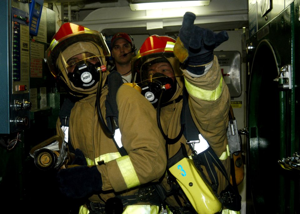 US Navy 070203-N-4649C-157 The on-scene leader, right, guides the nozzleman in the direction of a hot spot during a simulated class
