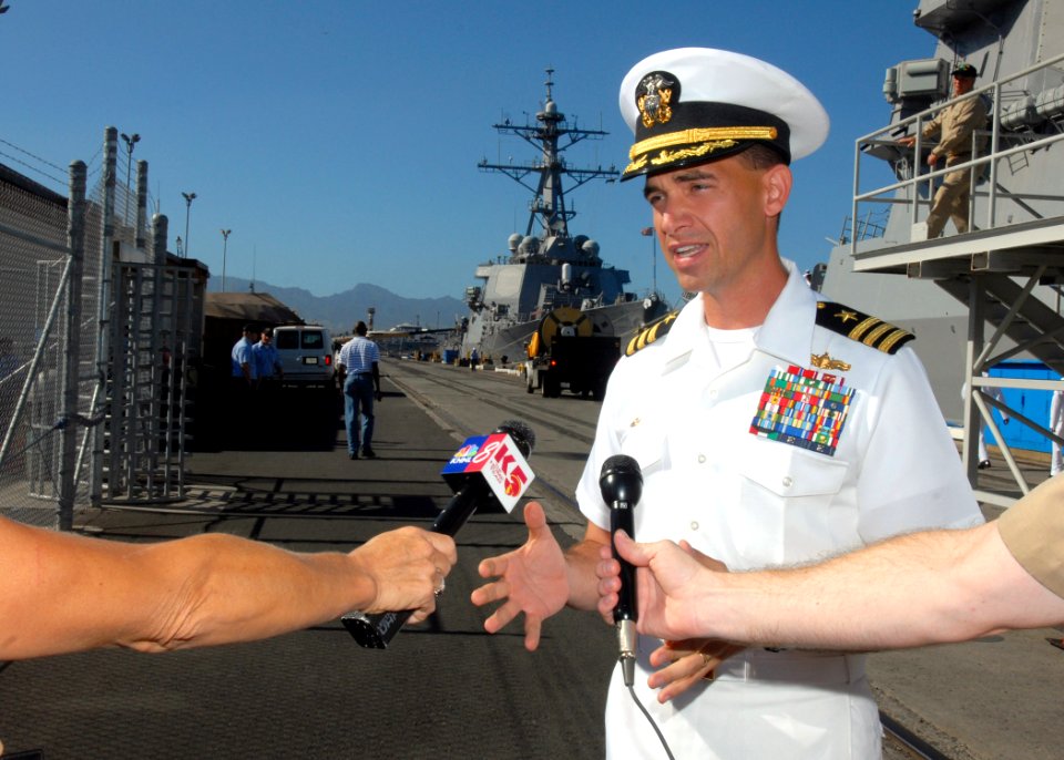 US Navy 070203-N-4965F-002 Commanding Officer of guided missile destroyer USS Russell (DDG 59) Cmdr. Brad Cooper answers questions for local media on the pier of Naval Station Pearl Harbor