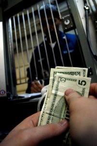 US Navy 070129-N-2659P-083 Personnel Specialist Seaman Chris Rasco receives money from Electronics Technician 3rd Class Adam Stevenson to put on his Navy cash card while visiting the disbursing office aboard Nimitz-class aircra