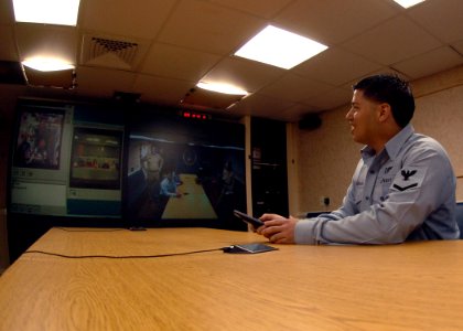 US Navy 070129-N-0490C-006 Following his reenlistment, Aviation Boatswain's Mate (Handling) 3rd Class Dubiell De Zarraga enjoys a unique opportunity to talk to astronauts orbiting 200 miles above earth, U.S. Navy Capt. Mi