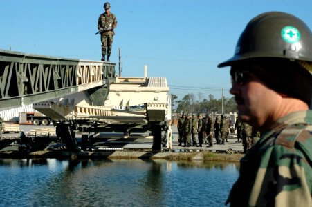 US Navy 070129-N-7367K-004 Builder Constructionman Douglas Norris, left, a Seabee assigned to Naval Mobile Construction Battalion One (NMCB-1), is one of the first students in the Medium Girder Bridge Course to test the bridge
