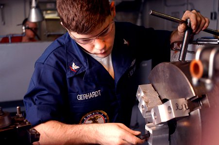 US Navy 070126-N-3038W-078 Machinery Repairman 3rd Class Anthony Gerhardt prepares the lathe for finishing cuts on brass couplings in the machining shop aboard the Nimitz-class aircraft carrier USS John C. Stennis (CVN 74)