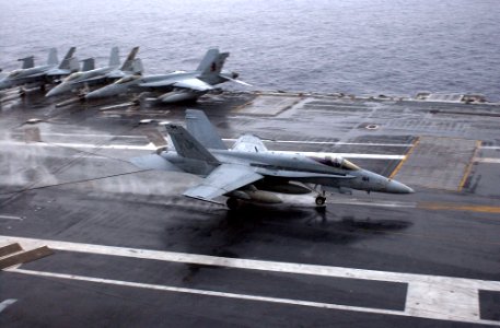 US Navy 070130-N-9712C-005 An F-A-18C Hornet assigned to the Fists of the Fleet of Strike Fighter Squadron Two Five (VFA-25), lands aboard USS Ronald Reagan (CVN 76) in the rain