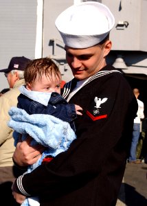 US Navy 070131-N-8544C-036 Electronics Technician 3rd Class Lee Medlin embraces his three-month-old son at the homecoming ceremony for guided missile frigate USS Boone (FFG 28)