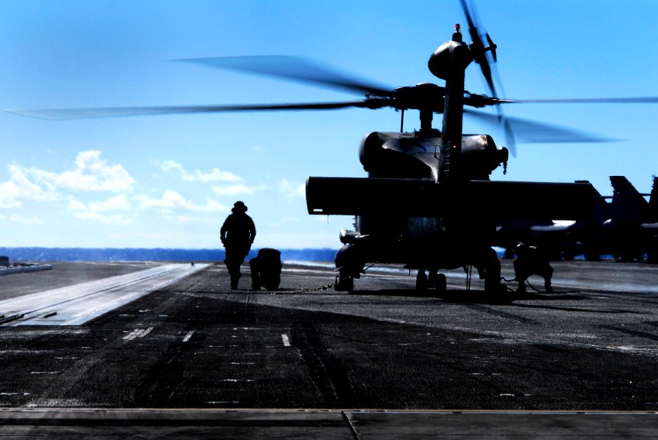 US Navy 070128-N-3729H-026 A landing signalman enlisted (LSE) assigned to the Eightballers of Helicopter Anti-Submarine Squadron Eight (HS-8) directs line personnel under the rotor-arc of an SH-60F Seahawk