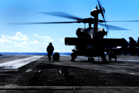 US Navy 070128-N-3729H-026 A landing signalman enlisted (LSE) assigned to the Eightballers of Helicopter Anti-Submarine Squadron Eight (HS-8) directs line personnel under the rotor-arc of an SH-60F Seahawk
