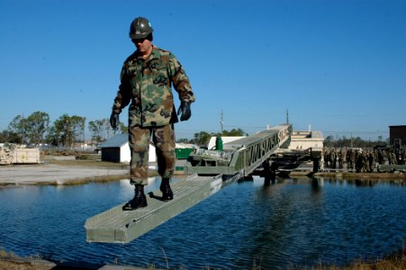 US Navy 070129-N-7367K-005 Steelworker 1st Class Bobby Wilson, a Seabee assigned to Naval Mobile Construction Battalion One (NMCB-1), is one of the first to cross an near-complete, medium girder bridge (MGB) as part of training photo