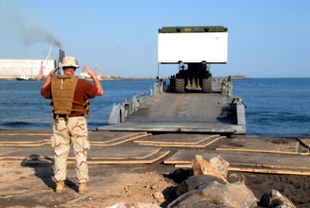 US Navy 070203-N-1226D-145 Boatswain's Mate Tony Nunez, a reservist with Beach Master's Unit One (BMU-1), Team C, gives directions to a Kalmar Rough Terrain Container Handler