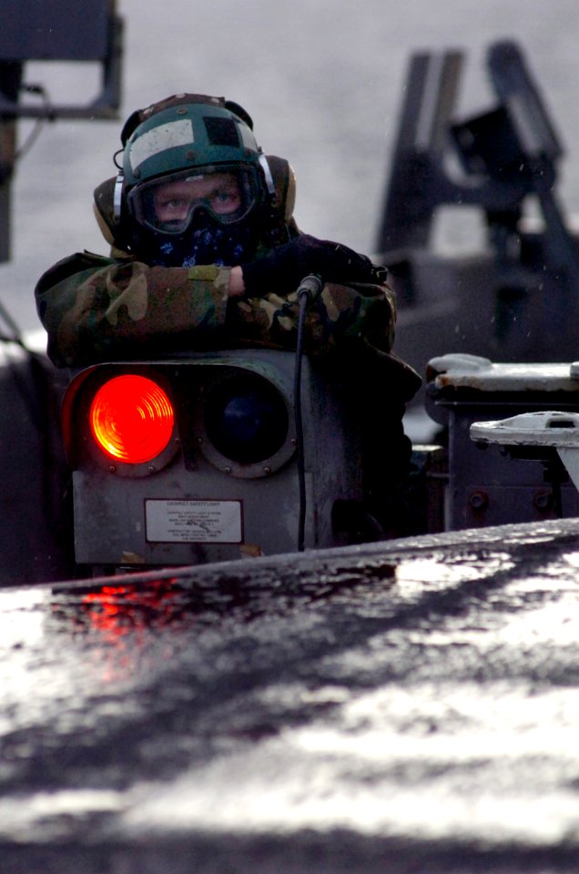 US Navy 070130-N-0555B-129 Safe from the pouring rain in a Gore-tex jacket, an aviation boatswain's mate (equipment) keeps a watchful eye on the activities on the flight deck aboard USS Ronald Reagan (CVN 76)