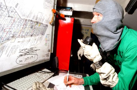 US Navy 070203-N-4009P-176 Mass Communication Specialist 2nd Class Christopher Blachly from Ridgecrest, Calif., receives a message in a repair locker during a general quarters (GQ) drill aboard Nimitz-class aircraft carrier USS