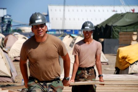 US Navy 070204-N-3589B-001 Sailors assigned to Amphibious Construction Battalion One (ACB-1) retrieve wood that will be used for the deck of a medical tent during the Humanitarian Support over the Shore (HSOTS) 2007 photo