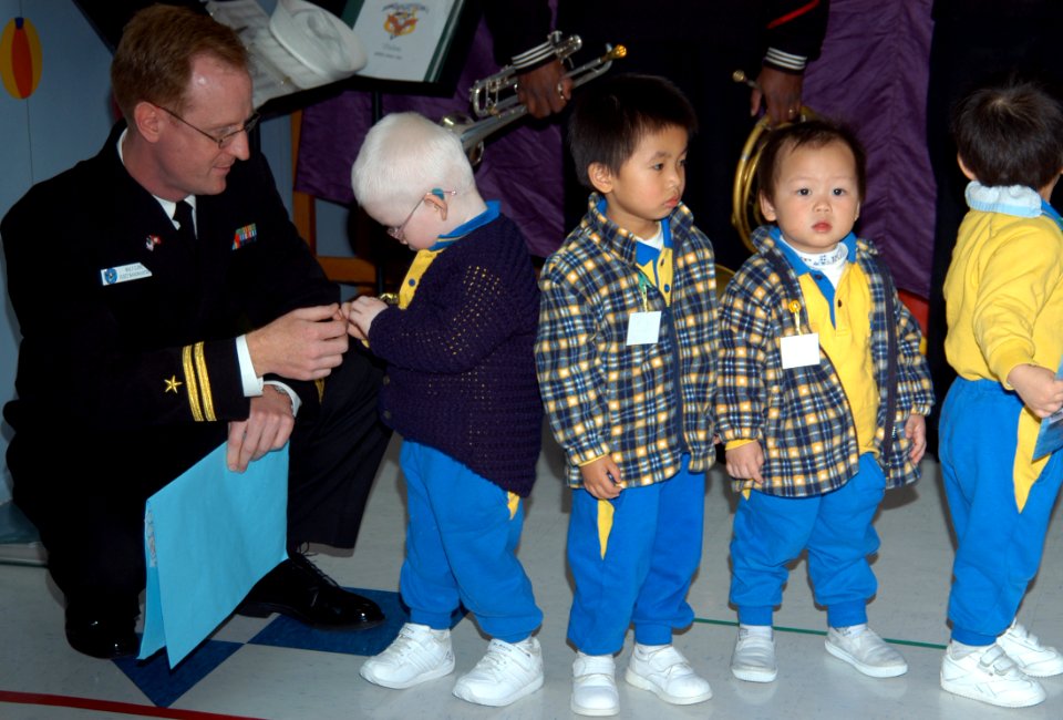 US Navy 070205-N-9604C-308 Lt. Walt Cline, bandmaster of the 7th Fleet Navy Band, talks to a group of students at the Society for Protection of Children, Hok Sam House nursery school