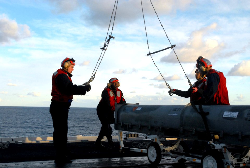US Navy 070131-N-2959L-036 Fire Controlman 1st Class Joshua Ashly, from Bridgeport Conn., pushes a NATO Sea Sparrow Missile into place under the grove crane on the flight deck aboard USS Ronald Reagan (CVN 76)