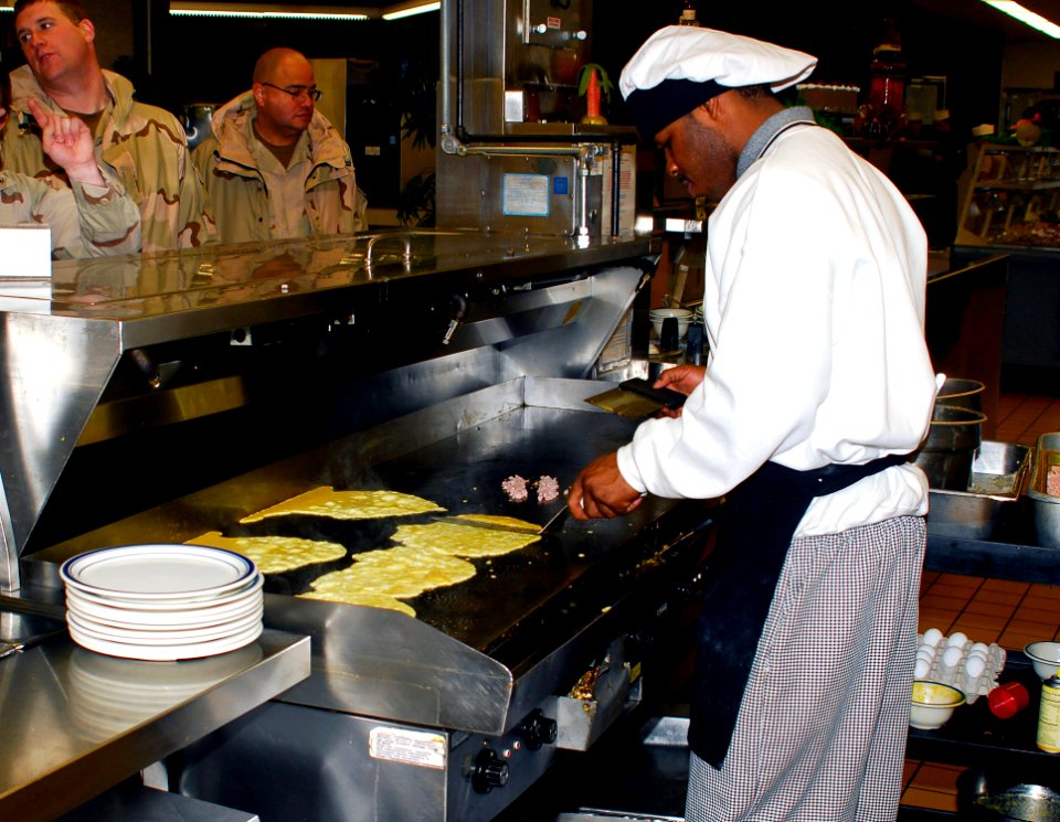 US Navy 070206-N-1831S-018 Culinary Specialist 3rd Class Eric Williams prepares eggs for the breakfast crowd