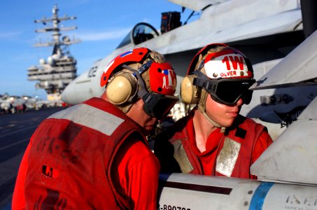 US Navy 070206-N-0555B-336 Aviation Ordnancemen assigned to the Fighting Redcocks of Strike Fighter Squadron Twenty Two (VFA-22) load an inert missile onto an F-A-18E Super Hornet on the flight deck aboard USS Ronald Reagan (CV