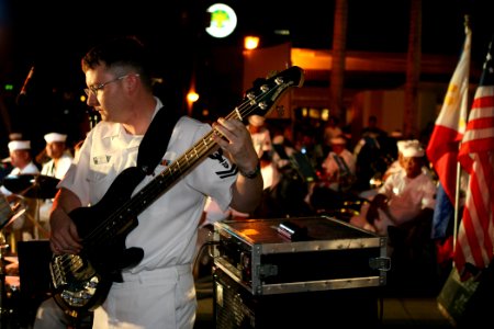US Navy 070209-N-1113S-013 With the Philippine and American national flags in the background, Musician 2nd Class Richard Bruns plays bass guitar during a joint U.S. 7th Fleet Band and Philippine Navy Band concert, held at Rajah
