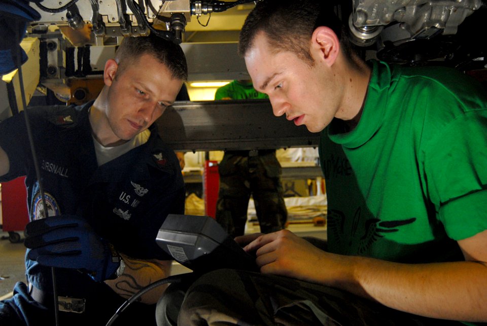 US Navy 070207-N-3038W-121 Aviation Machinist's Mate 1st Class Zachary Bursnall helps Aviation Machinist's Mate 2nd Class Jarred McKie boroscope an F-A-18F Super Hornet engine in the jet engine shop aboard Nimitz-class aircraft