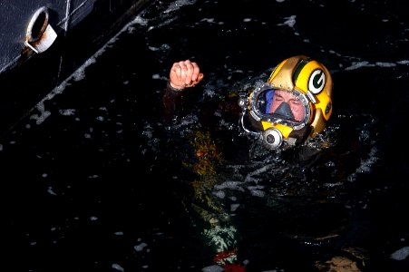 US Navy 070212-N-8327R-056 Navy Diver 2nd Class Richard Nieves simulates the bends as he emerges from the water after a standard cofferdam removal during a routine training exercise