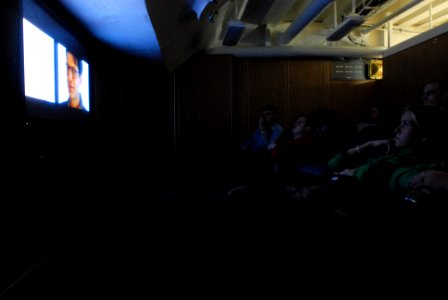 US Navy 070206-N-2959L-555 Sailors take a break from their hectic days to catch a movie in the theater in the library aboard USS Ronald Reagan (CVN 76)