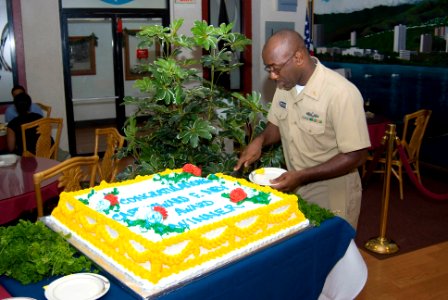 US Navy 070207-N-4856G-009 Chief Quartermaster James Watkins cuts himself a slice of the Ney Award cake in honor of the Edward F. Ney Award won by Naval Station Pearl Harbor's Silver Dolphin Bistro