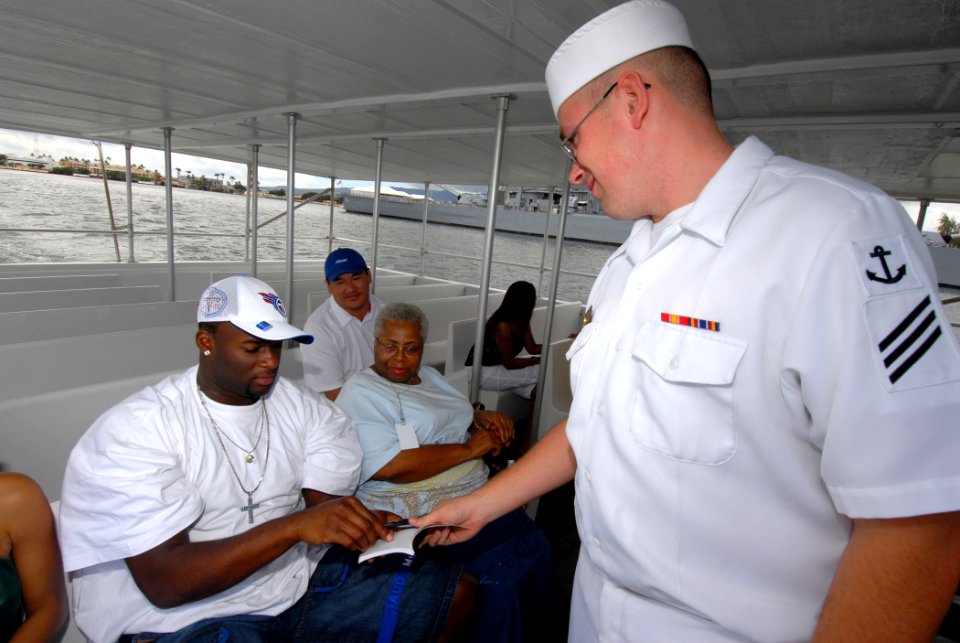 US Navy 070209-N-4965F-001 Seaman Christopher Haney, bow hook for the USS Arizona Memorial Detachment white boat crew, asks for an autograph from Vince Young, quarterback for the National Football League's Tennessee Titan