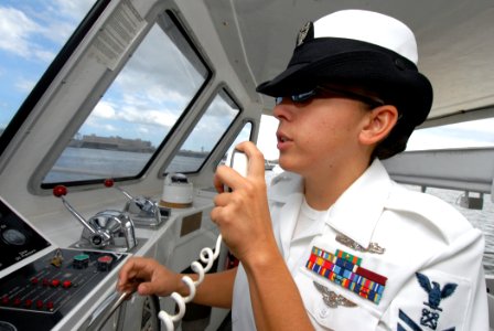 US Navy 070209-N-4965F-009 Boatswain's Mate 2nd Class Kelly Pfaus, coxswain for the USS Arizona Memorial Detachment, navigates a white boat during a historic tour of Pearl Harbor for NFL players and their family and friends