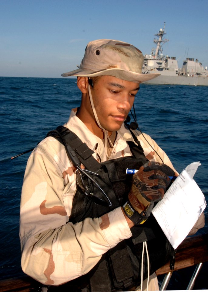 US Navy 070209-N-8623S-007 Ensign Samuel Robinson, a USS Ramage (DDG 61) boarding team leader, takes notes as he speaks with the master of a fishing dhow during visit, board, search and seizure (VBSS) operations