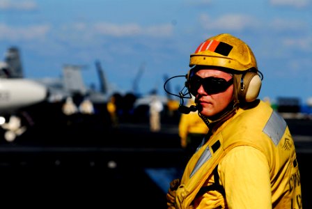 US Navy 070216-N-3729H-011 Aviation Boatswain's Mate Chief Richard Harmor monitors the safe movement of aircraft aboard the Nimitz-class aircraft carrier USS John C. Stennis (CVN 74)