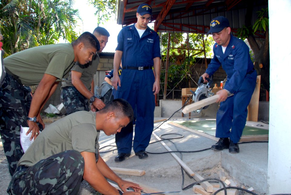 US Navy 070209-N-9860Y-778 Machinist's Mate 1st Class Arnel Gernale of Bulansorsogon, Philippines, and Aerographer's Mate 1st Class Tyler Mello of Atwater, Calif., help Seabees from the Philippine navy