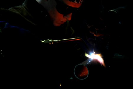 US Navy 070208-N-7367K-002 Steelworker 3rd Class Michael Streator, assigned to Naval Mobile Construction Battalion One (NMCB-1), is gas cutting a steel pipe as an exercise part of the Gas Cutting and Welding II Course