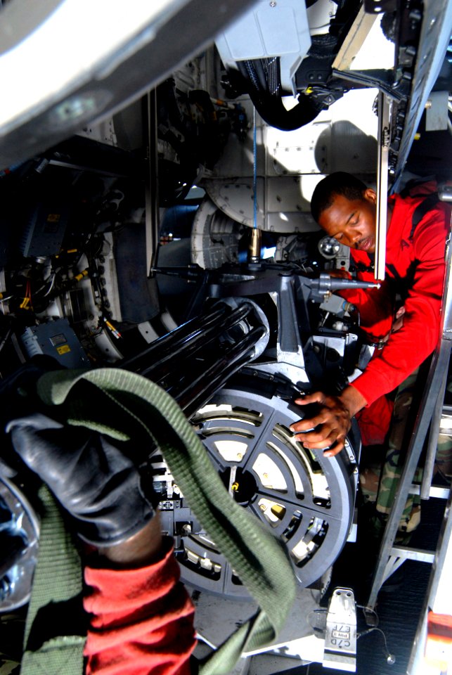 US Navy 070210-N-3038W-043 Aviation Ordnanceman 3rd Class Travis Alverson helps guide the gun turret onto rails so it can be raised into an F-A-18F Super Hornet