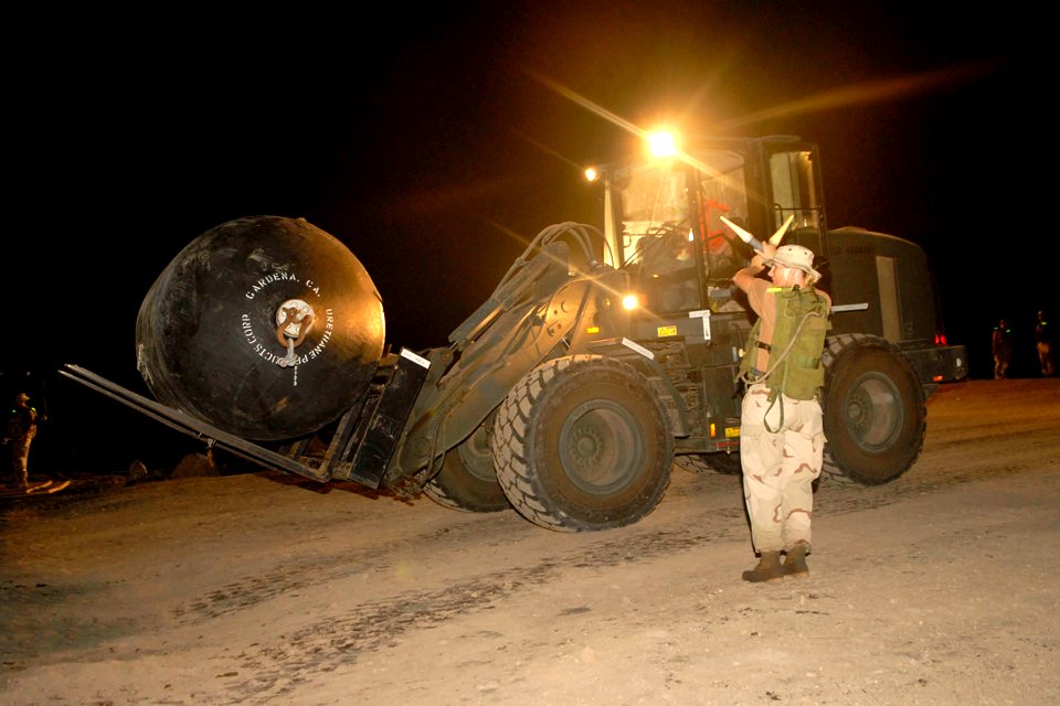 US Navy 070209-N-1226D-001 Quarter Master 2nd Class Dana Sabbe assigned to Beach Master Unit One, Team Gulf, directs a forklift during night operations in support of Humanitarian Support Over the Shore (HSOTS) 2007