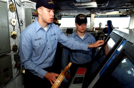 US Navy 070214-N-4009P-086 Quartermaster Seaman Mark Williams from Lubbock, Texas, steers the Nimitz-class aircraft carrier USS Ronald Reagan (CVN 76) while instructing Quartermaster Seaman Brandon Beyer