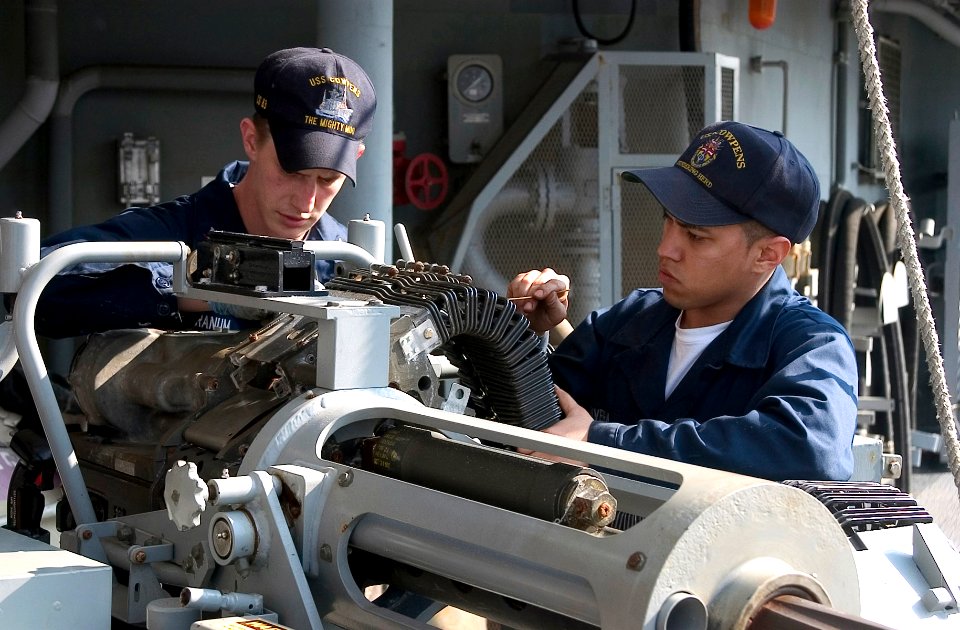 US Navy 070213-N-2638R-002 Gunner's Mate 3rd Class Shawn Branum and Gunner's Mate Seaman William Rivera clean a 25mm chain gun system aboard the Ticonderoga-class guided-missile cruiser USS Cowpens (CG 63)